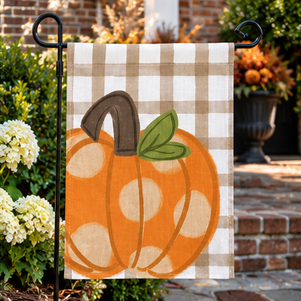 Polka dot pumpkin garden flag by a brick entryway with fall decor